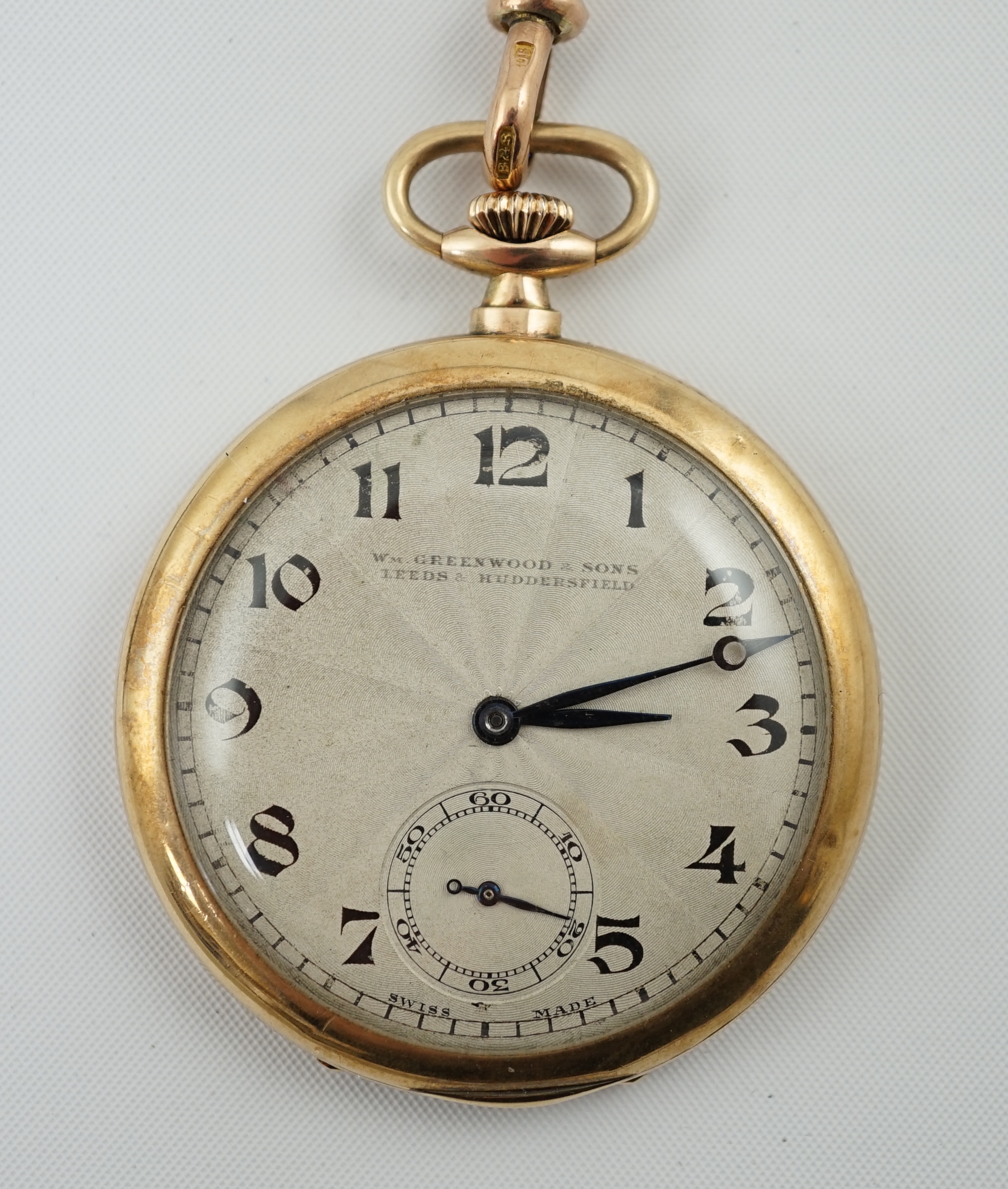 A George V 9ct gold open face dress pocket watch, retailed by William Greenwood & Sons, together with a 9ct gold albert